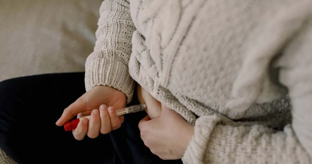 Person injecting themselves in the abdomen