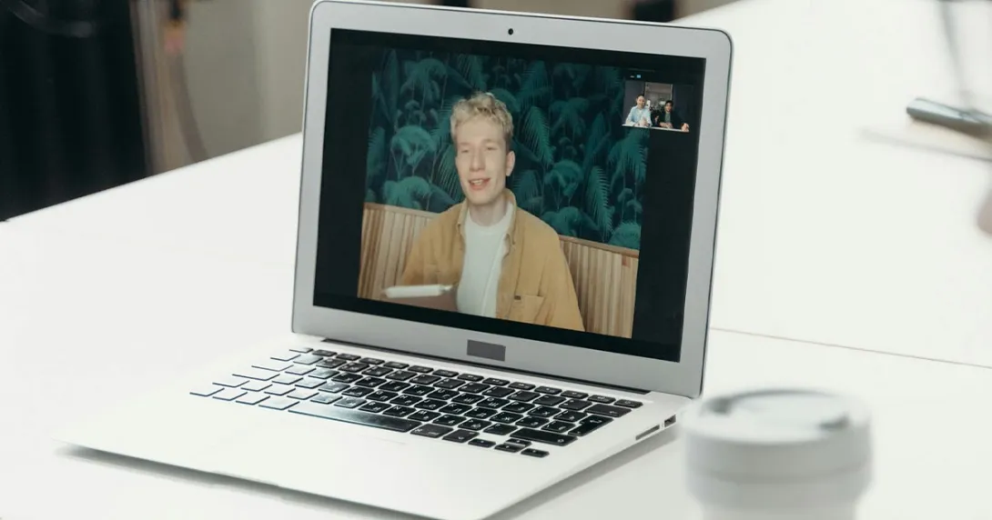 Laptop on a table showing the parties in a video meeting