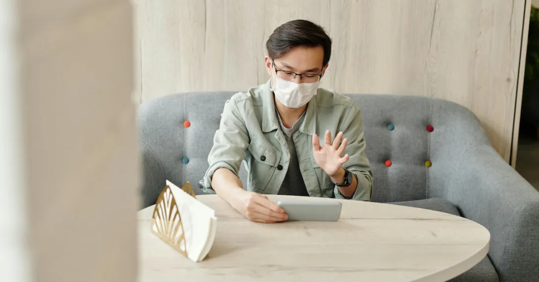A patient wearing mask at home in an online consultation.