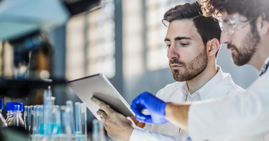 Lab workers looking at a tablet