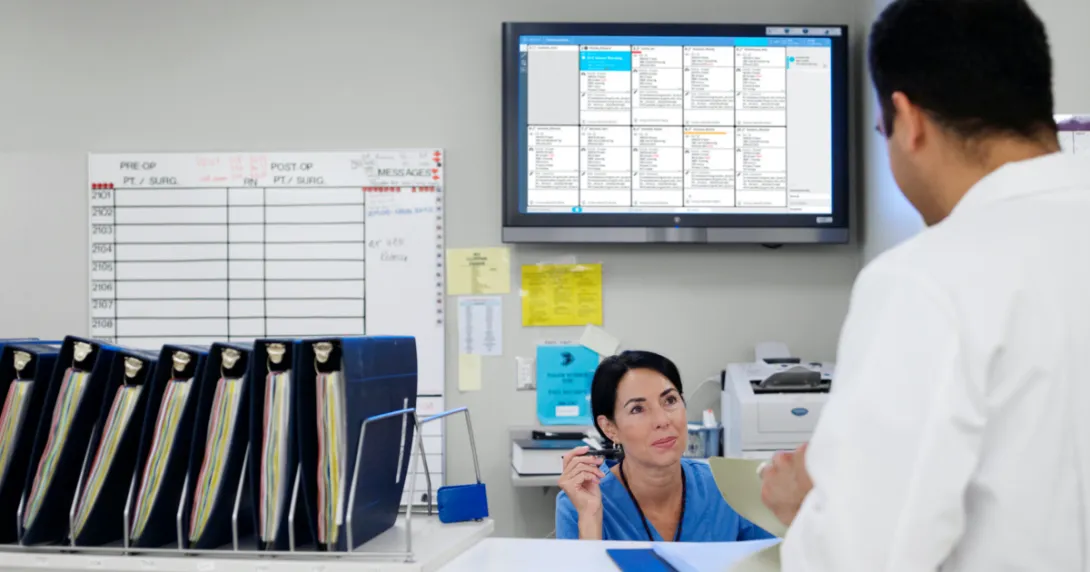 Staff conversing in the nurses' station with the Ascom Digistat Smart Central on the background
