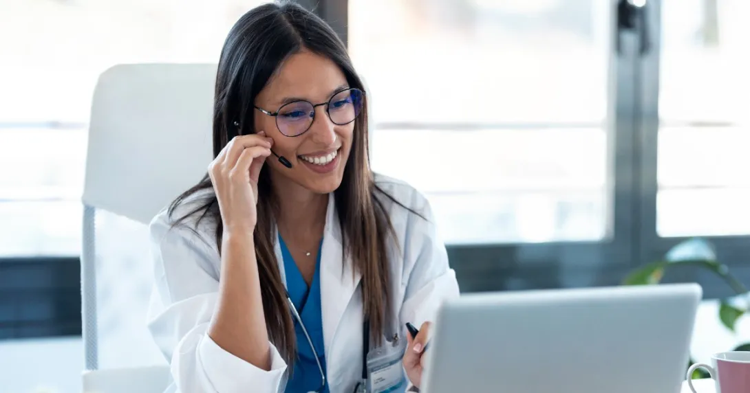 Female doctor with headset smiles on a telehealth visit