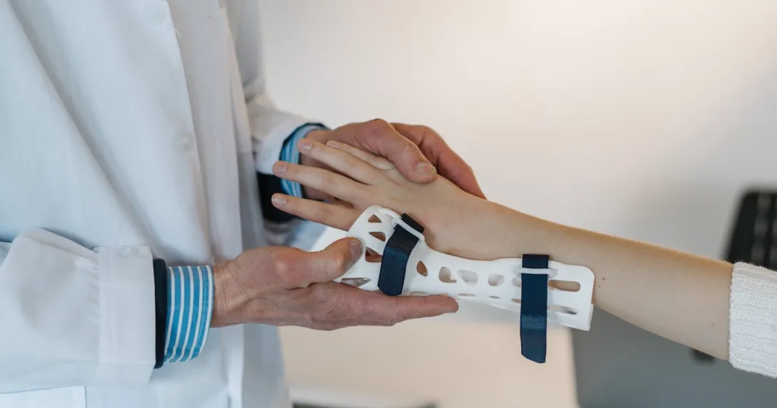 A doctor fitting a wrist brace on a patient