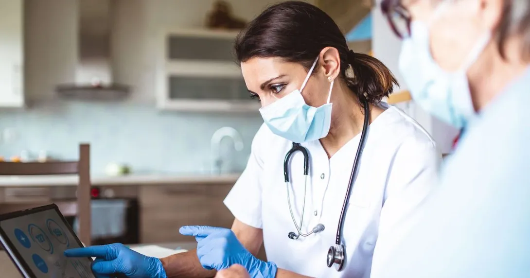 Two medical researchers in a lab look at information on a laptop