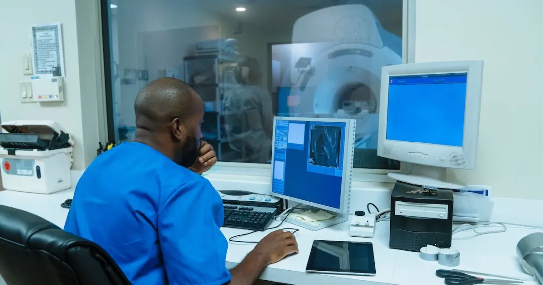 Healthcare worker using computer in MRI control room