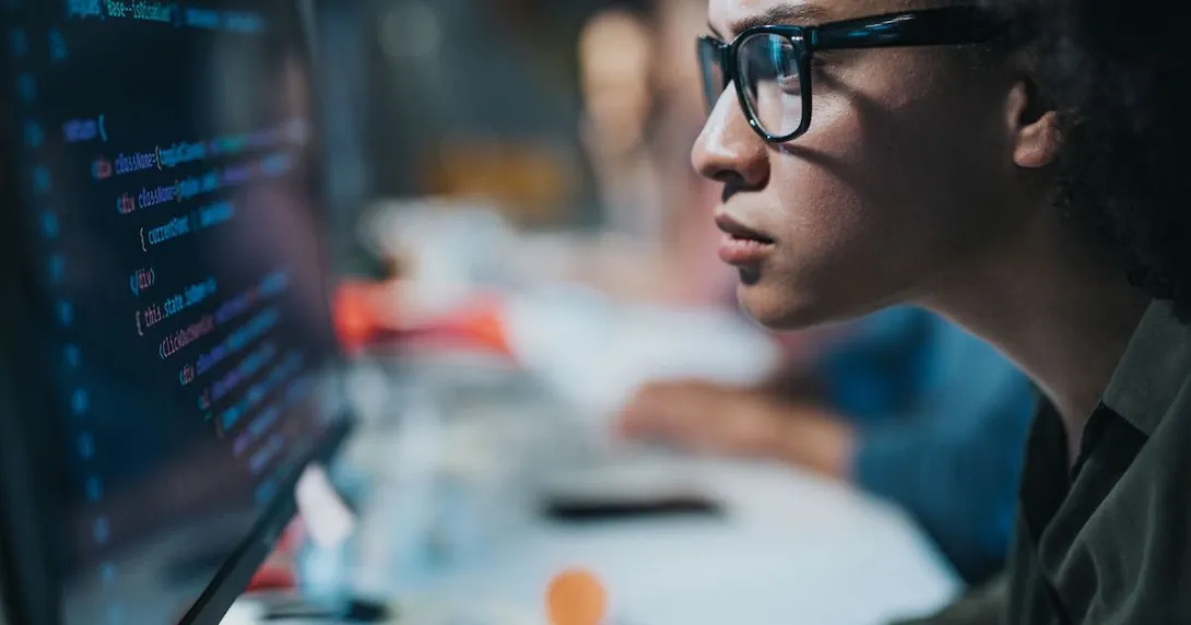A computer programmer coding in a desktop computer