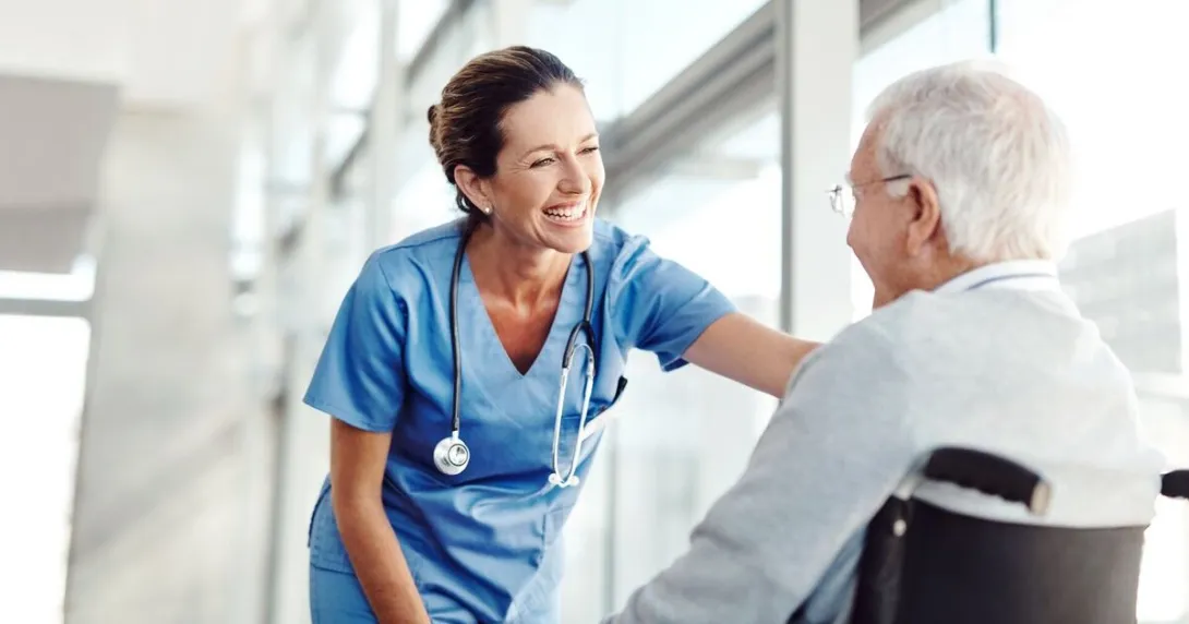 A nurse conversing with a senior patient in a wheelchair
