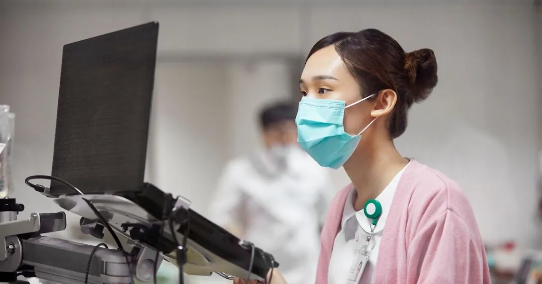 A nurse encoding a patient's record on a laptop