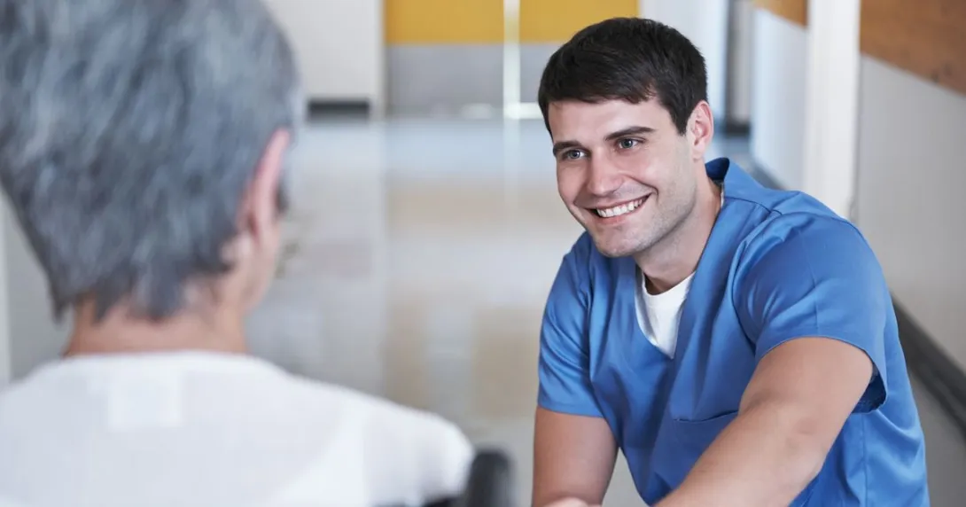 A nurse talking to a senior patient in a wheelchair