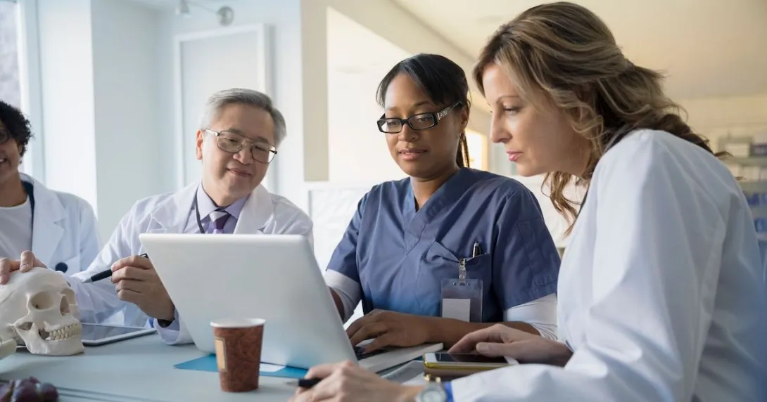 Health professionals using a laptop to collaborate remotely