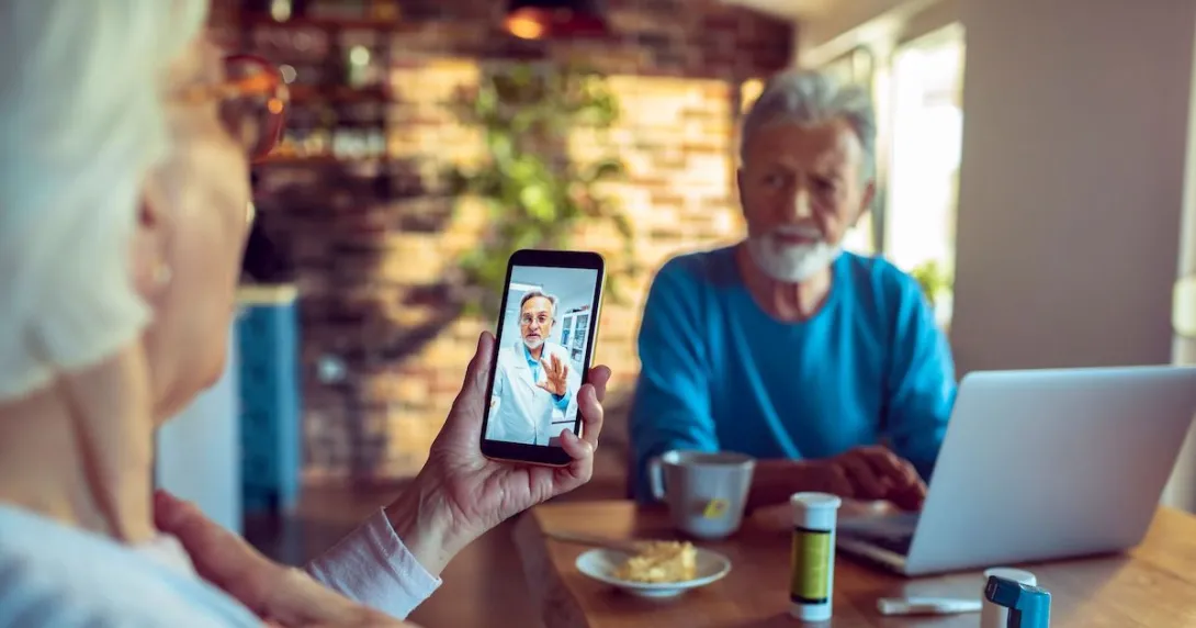 A senior patient in a video consultation with a doctor via mobile phone