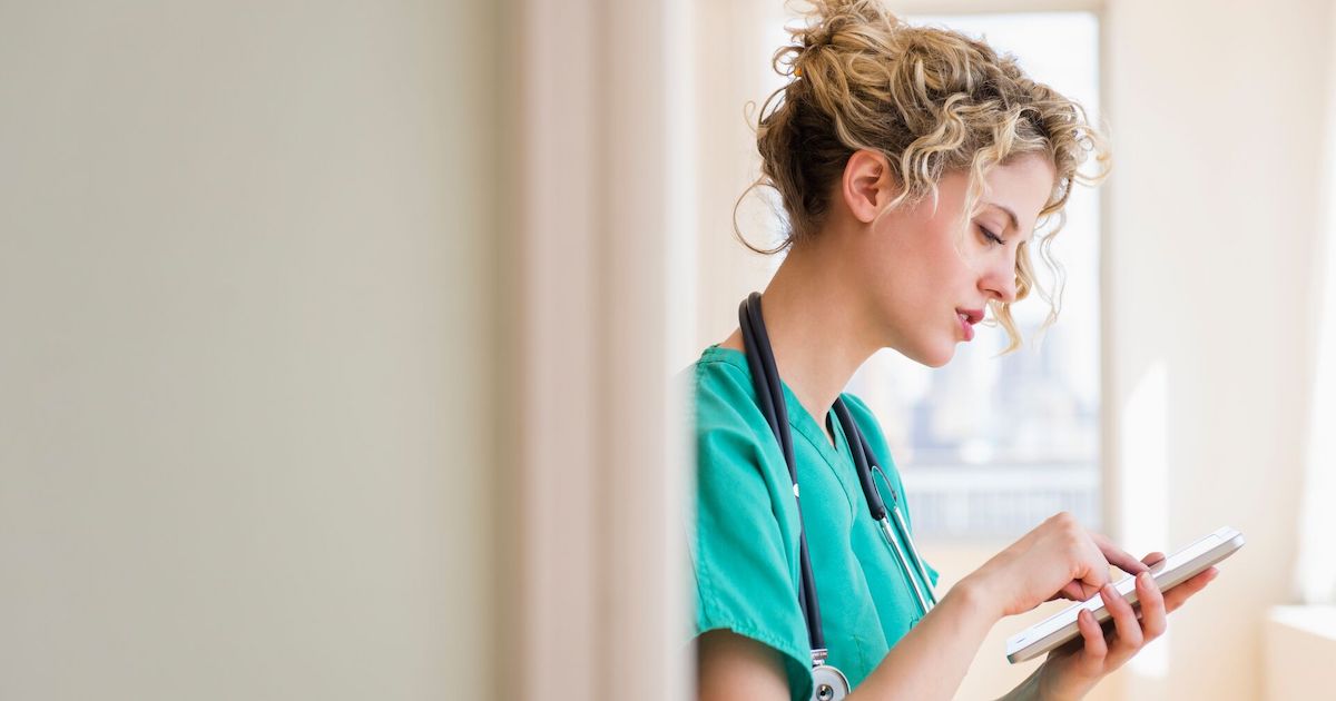 A nurse holding a digital tablet to check a patient's file